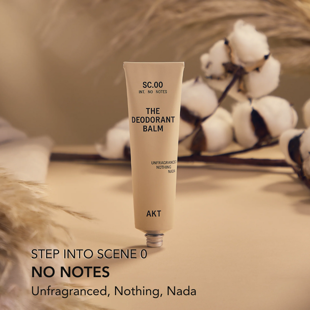Deodorant balm tube labeled 'SC.OO THE DEODORANT BALM' on a wooden surface with decorative elements.
