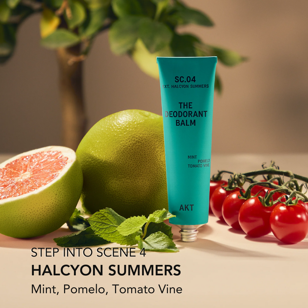 Green deodorant balm tube with pomelo, grapefruit, and tomatoes on a neutral background