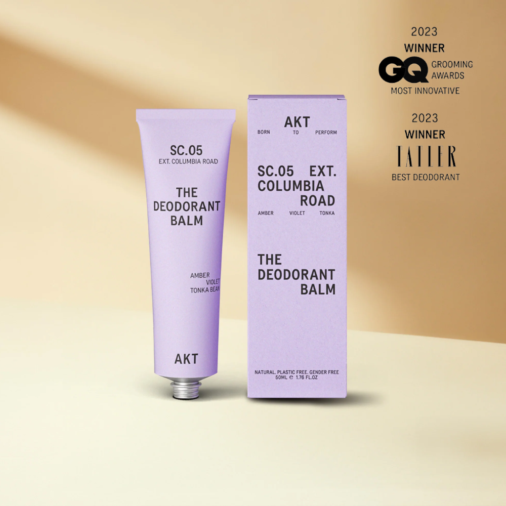 Deodorant balm with packaging on a beige background, featuring awards text.
