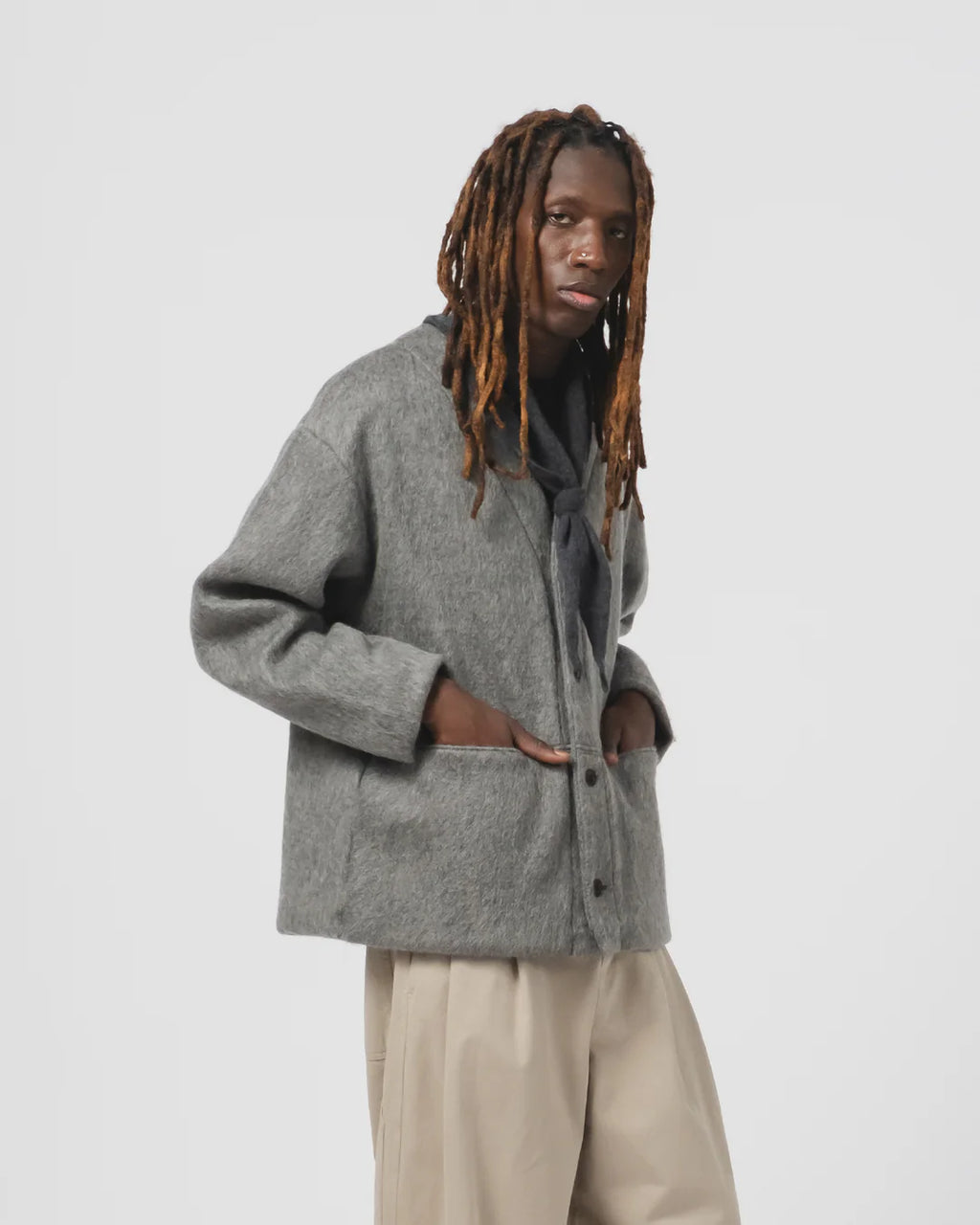 Person wearing a grey cardigan on a white background