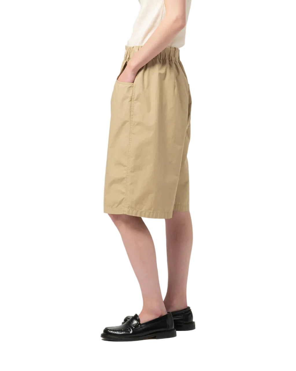 Person wearing beige Girls of Dust shorts on white background