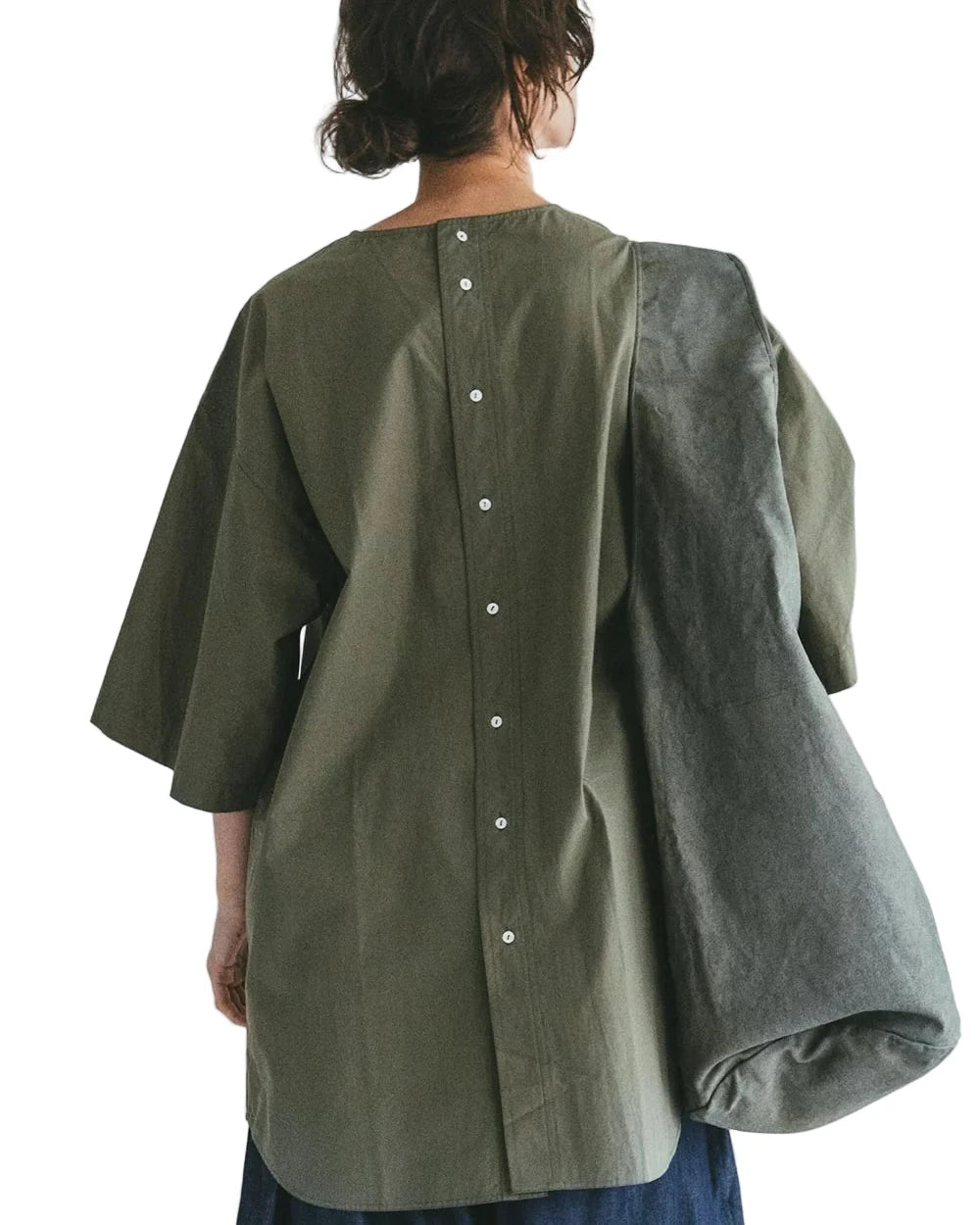 Person wearing a green oversized Fog Linen / Mii Thaai shirt with balloon sleeves on a plain background