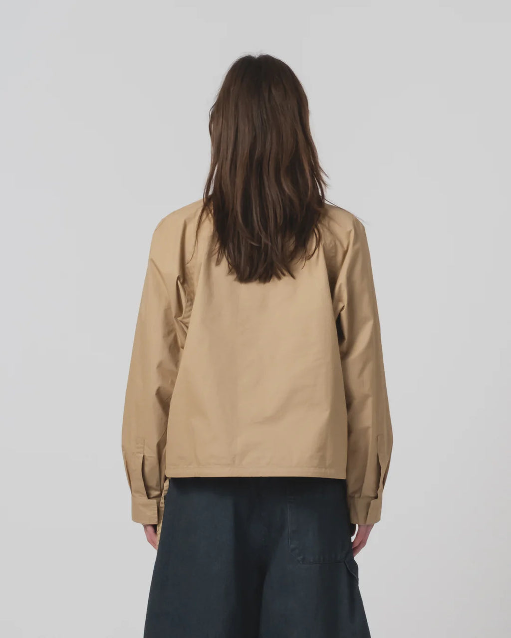 Person wearing a Girls of Dust beige shirt on a plain background 