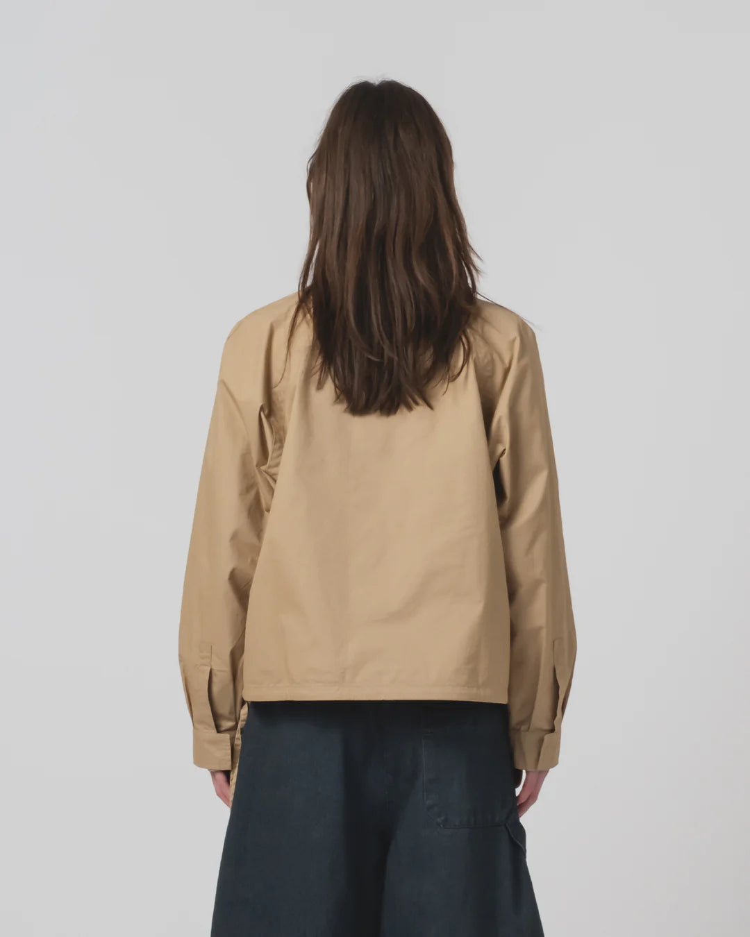 Person wearing a Girls of Dust beige shirt on a plain background 