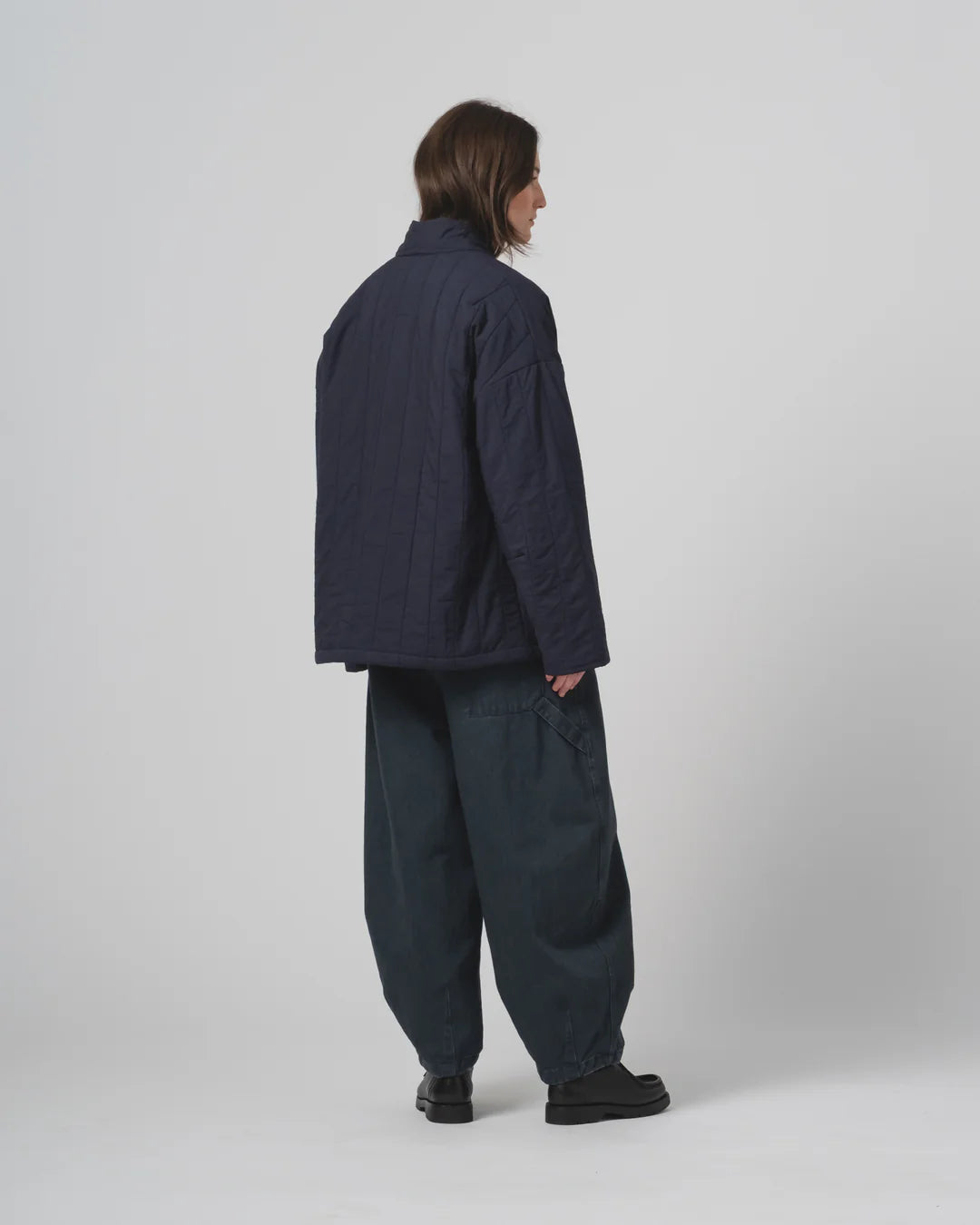 Person wearing a navy Girls of Dust Kimono inspired padded jacket against a white background 