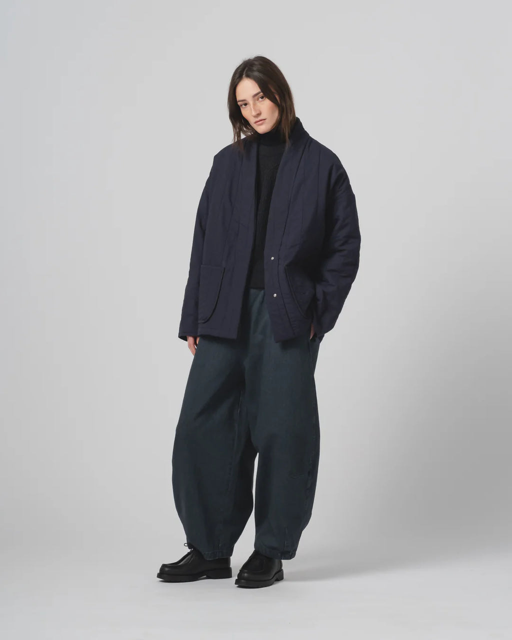 Person wearing a navy Girls of Dust Kimono inspired padded jacket against a white background 