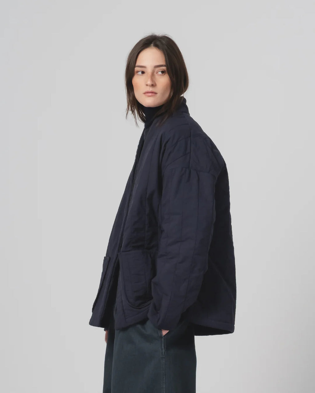 Person wearing a navy Girls of Dust Kimono inspired padded jacket against a white background 
