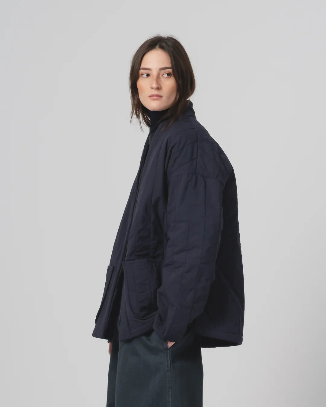 Person wearing a navy Girls of Dust Kimono inspired padded jacket against a white background 