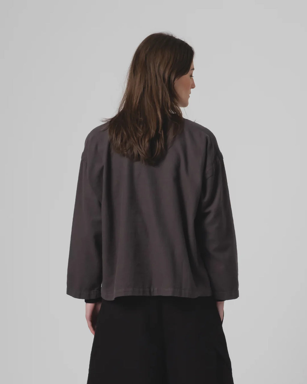 Person wearing a Girls of Dust dark grey top on a plain background