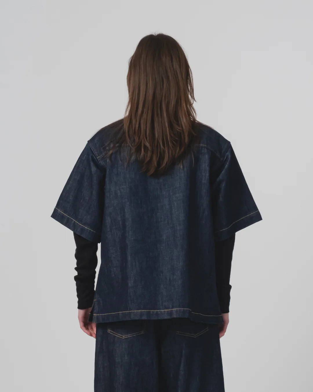 Person wearing an oversized Girls of Dust denim shirt and pants on a plain background