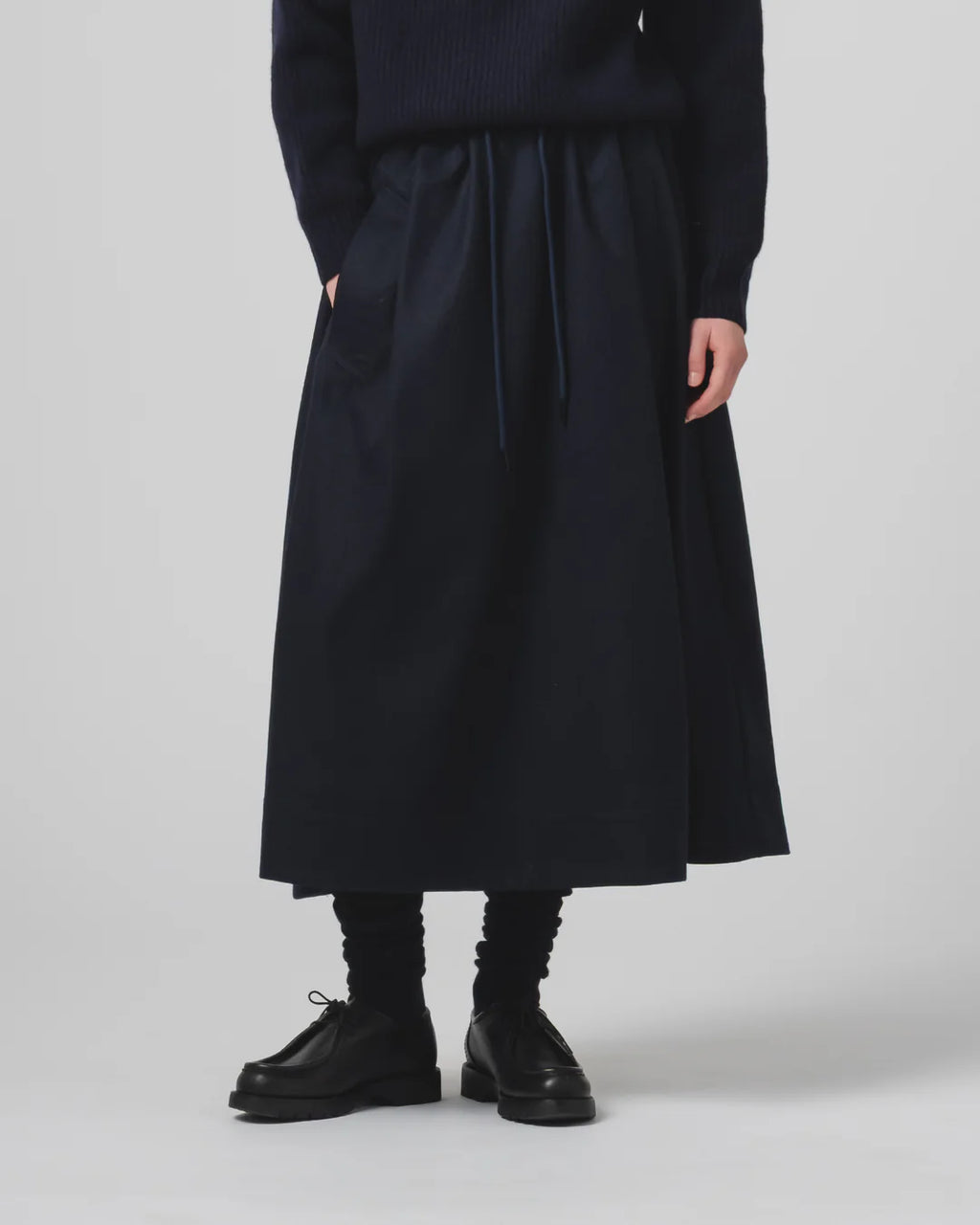Person wearing a Girls of Dust mid length dark navy skirt with a plain background