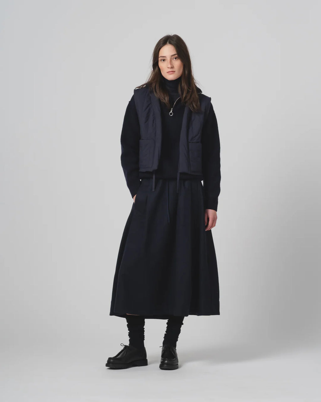 Person wearing a Girls of Dust Mid length dark navy skirt on a white background