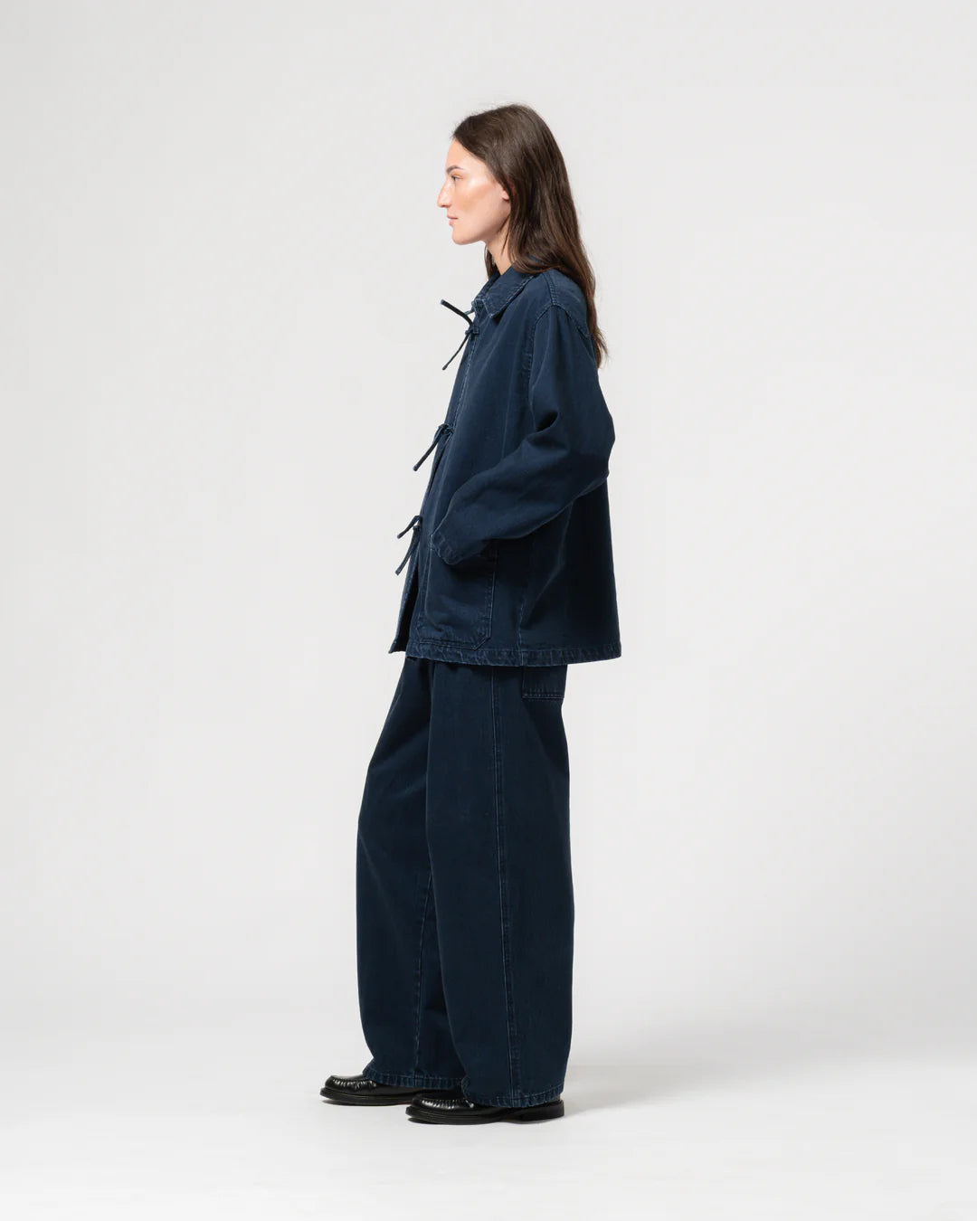 Person wearing a navy blue outfit on a white background