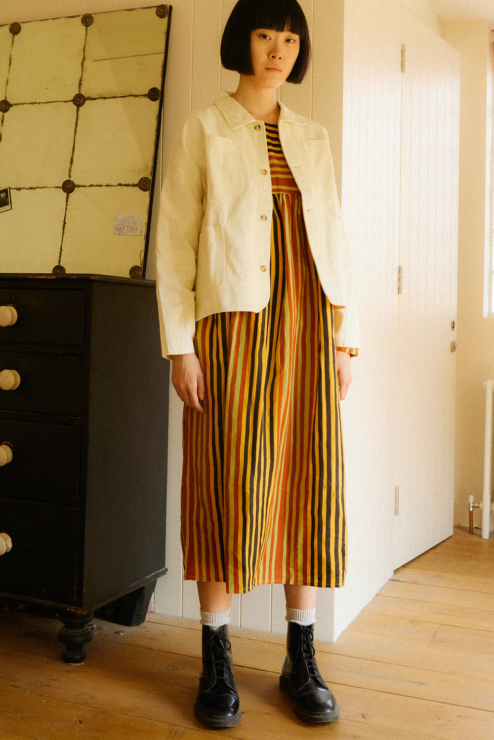 Women wearing the LF Markey striped dress with a white jacket in an indoor setting. 