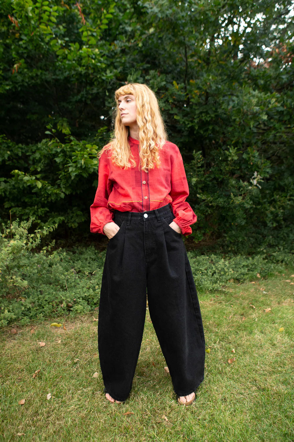 Person wearing LF MARKEY black Mason Jeans and a red shirt outside on some grass 