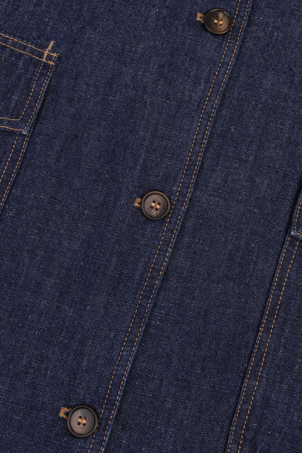 Close-up of a blue denim jacket with buttons and stitching details.