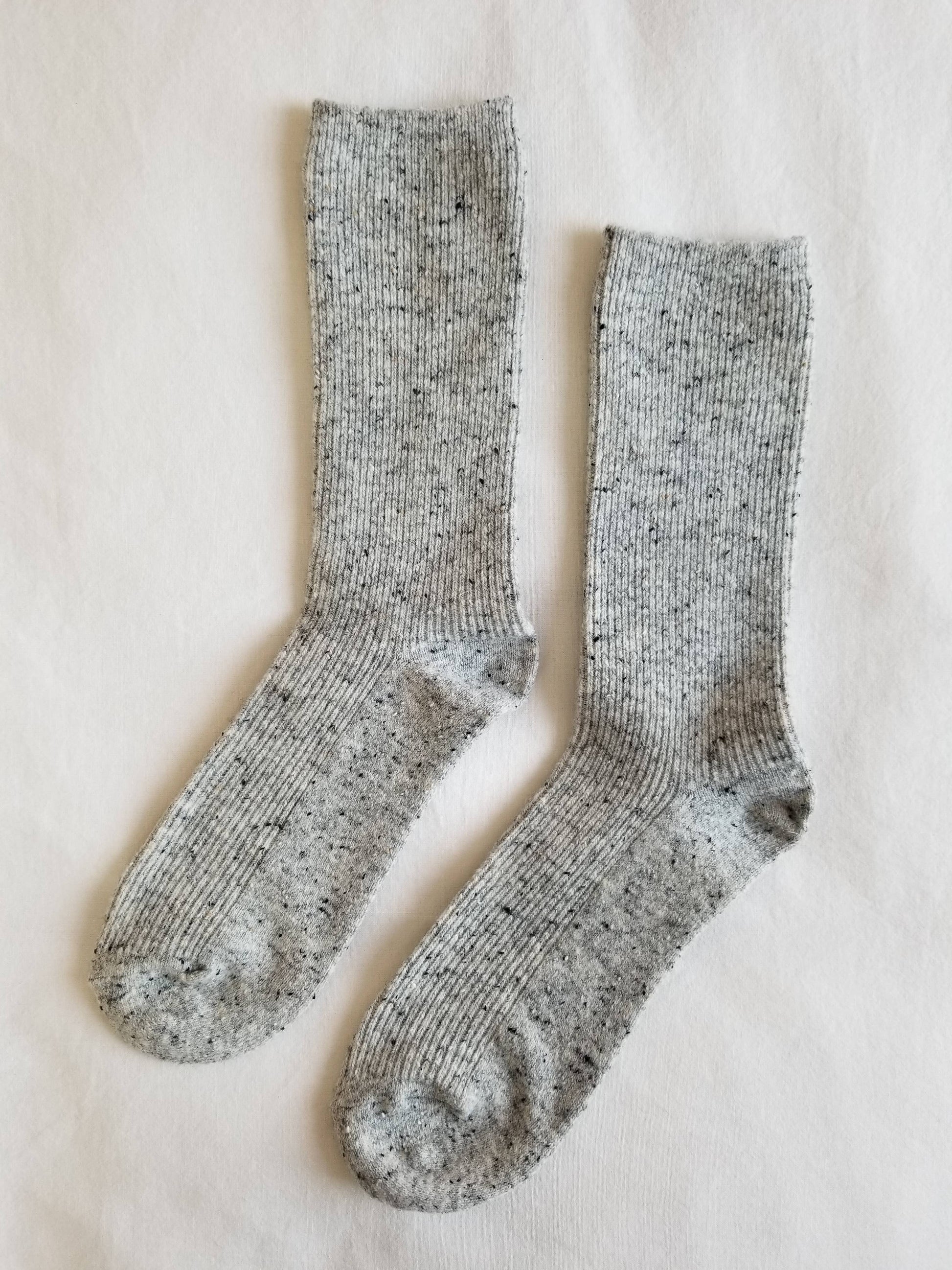 Pair of gray socks on a light beige background
