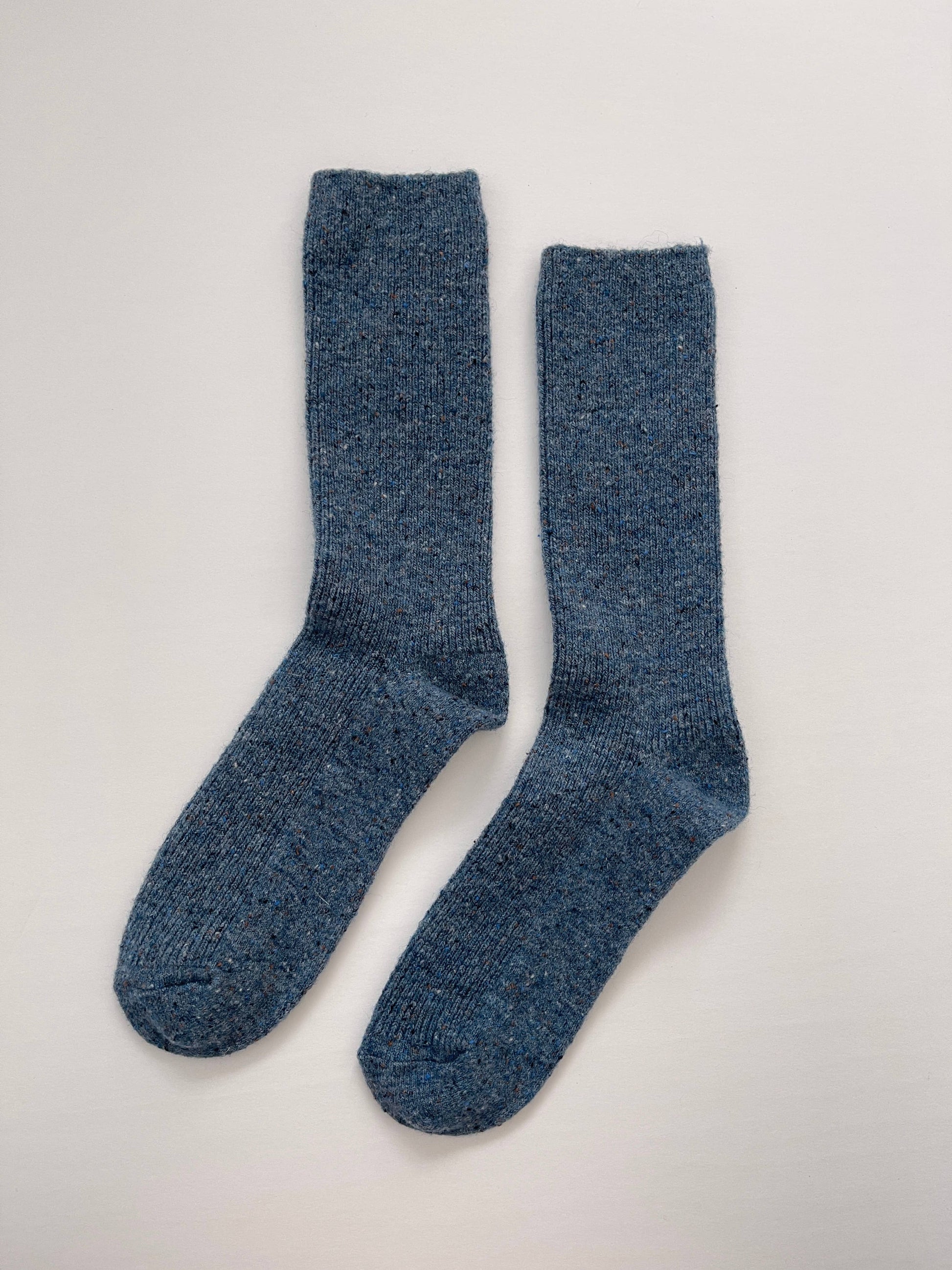 Pair of blue socks on a light gray background