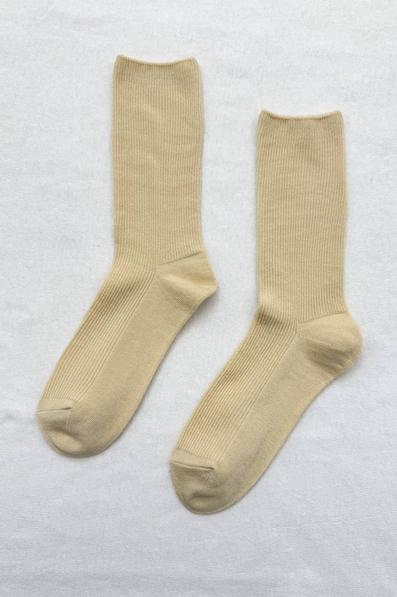 Pair of yellow Le Bon Shoppe socks on a light grey background