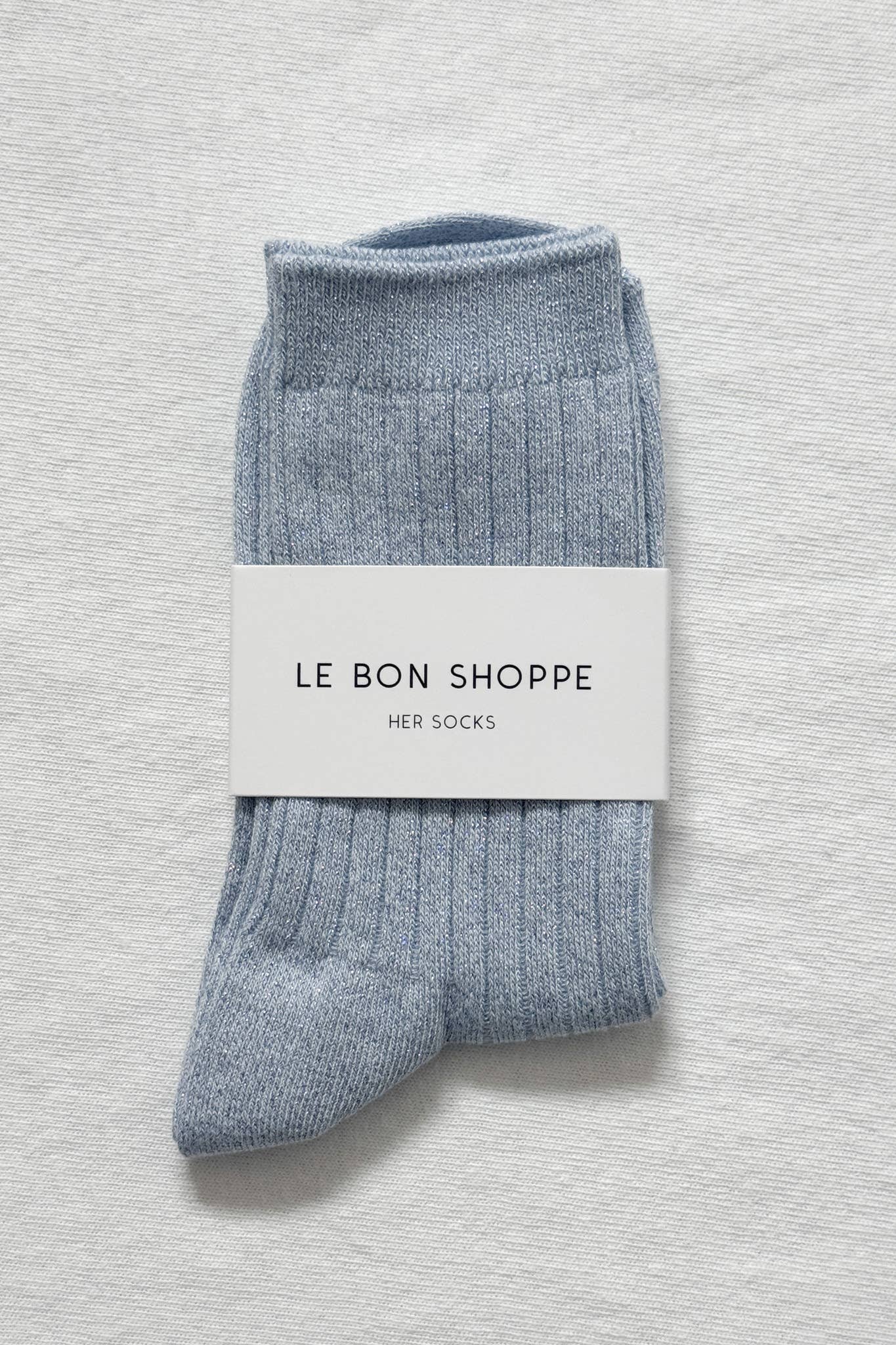 Blue socks with a 'Le Bon Shoppe' label on a light gray background