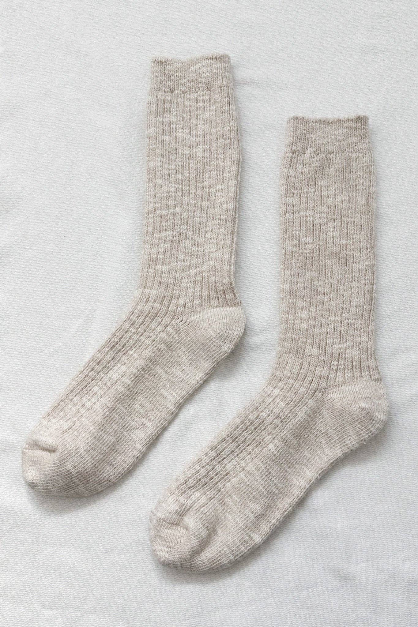 Pair of beige Le Bon Shoppe socks on a light grey background
