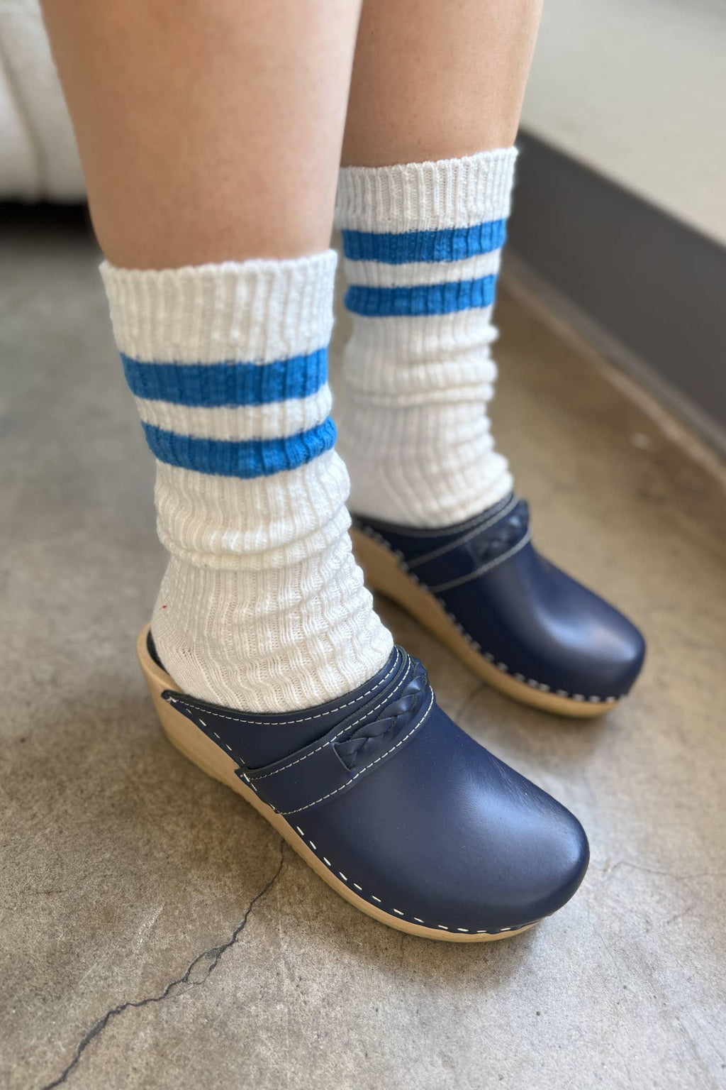 Le Bn. Shoppe White socks with blue stripes and navy clogs on a neutral background