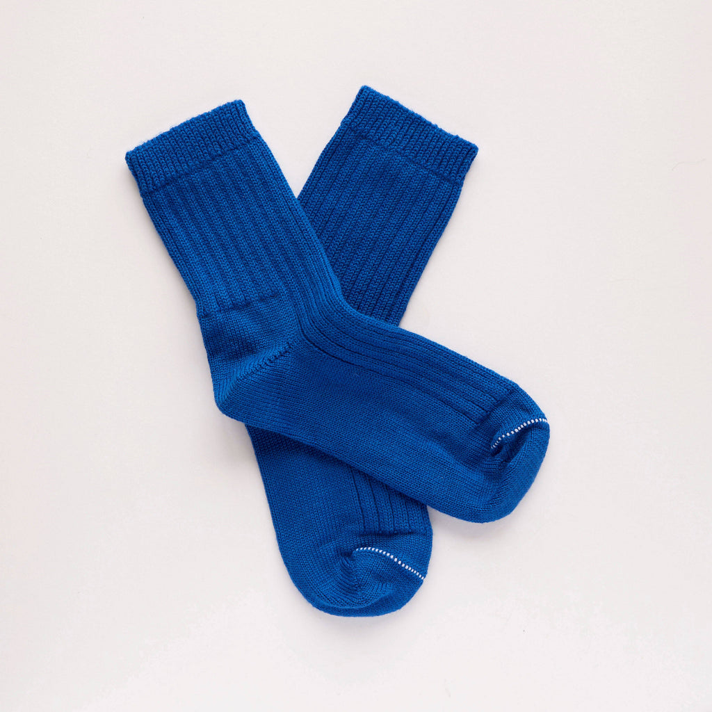 Pair of blue socks on a light gray background