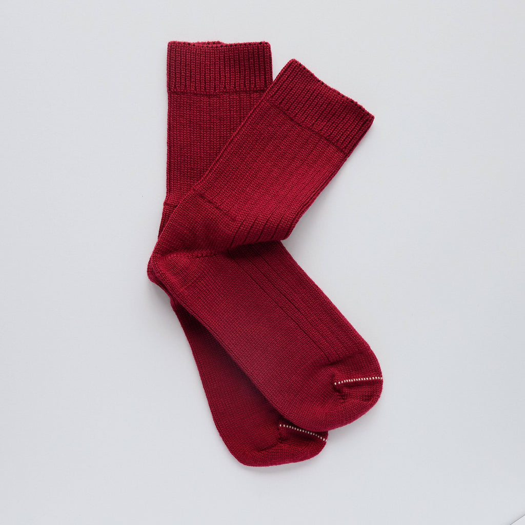 Pair of red socks on a light gray background