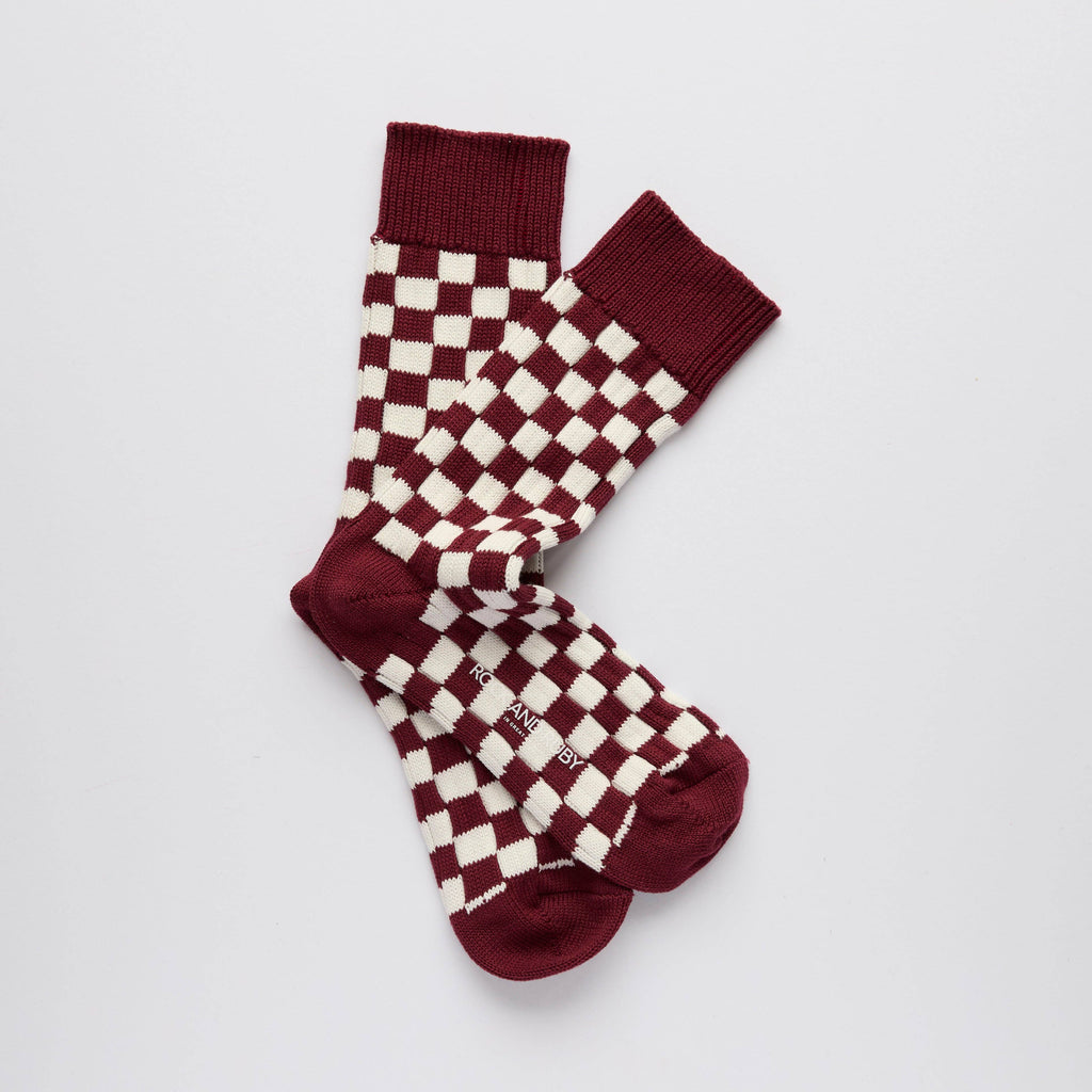 Pair of red and white checkered socks on a light gray background