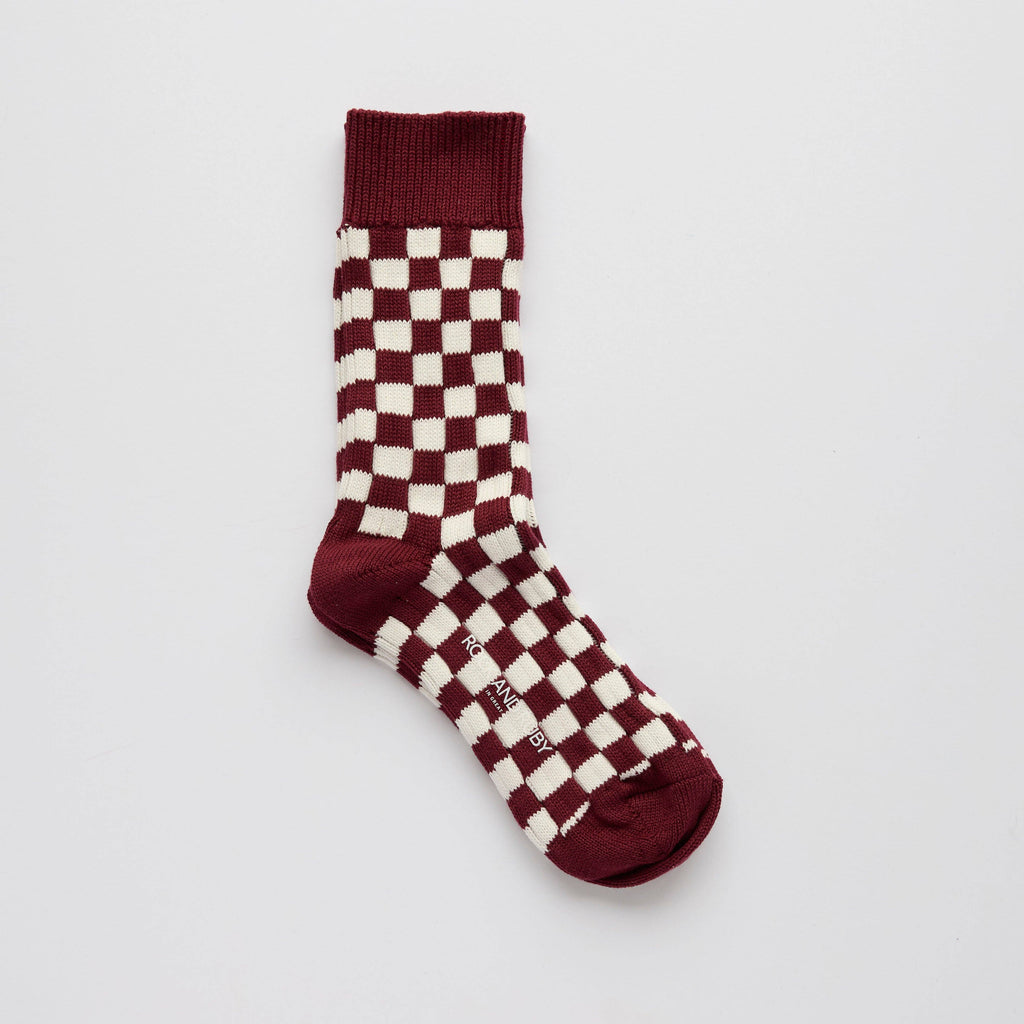 Maroon and white checkered sock on a light gray background