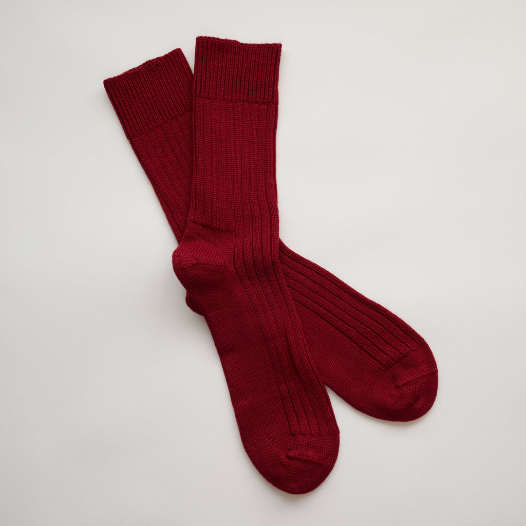 Pair of red socks on a light gray background