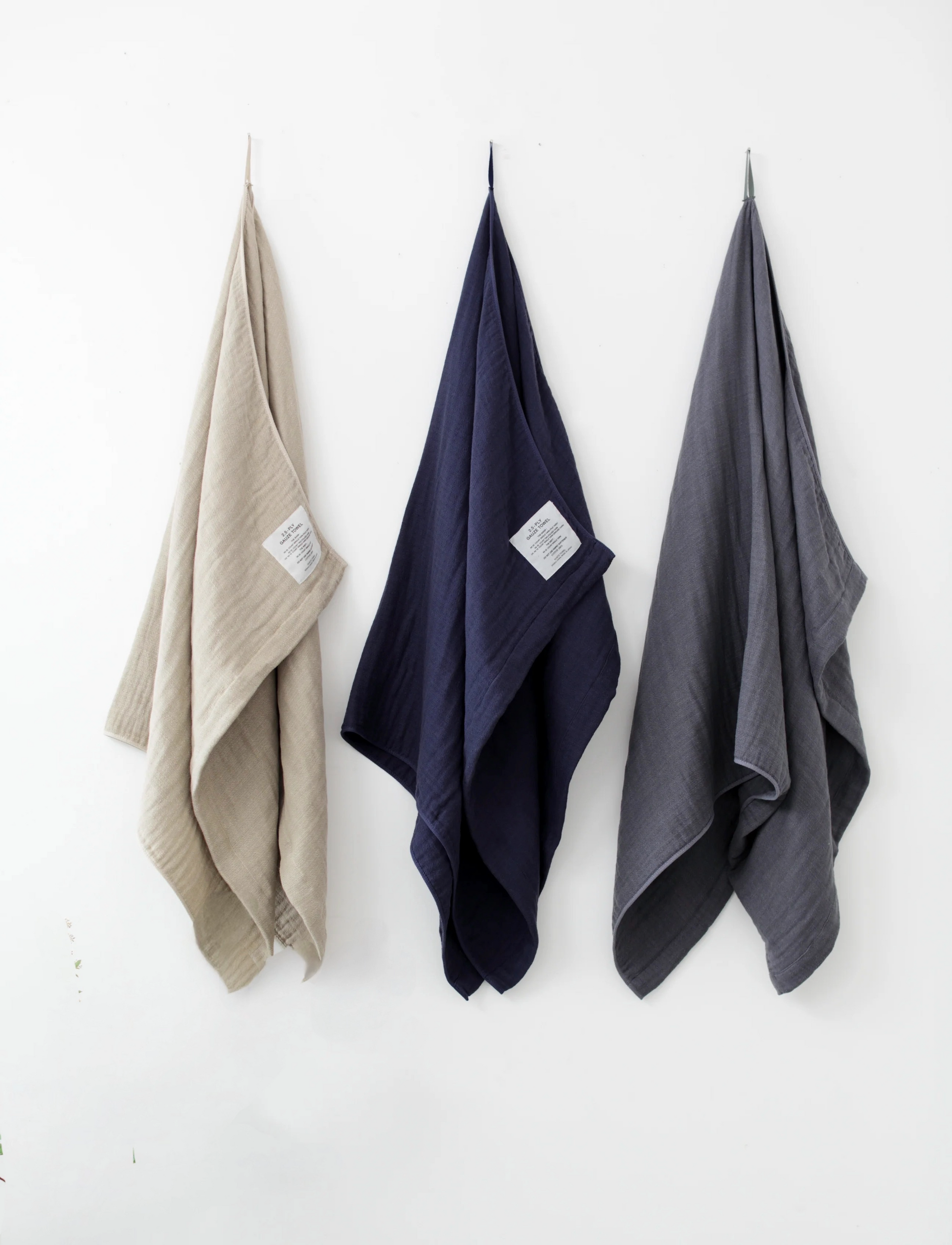 Three Shinto towels hanging on a white wall 
