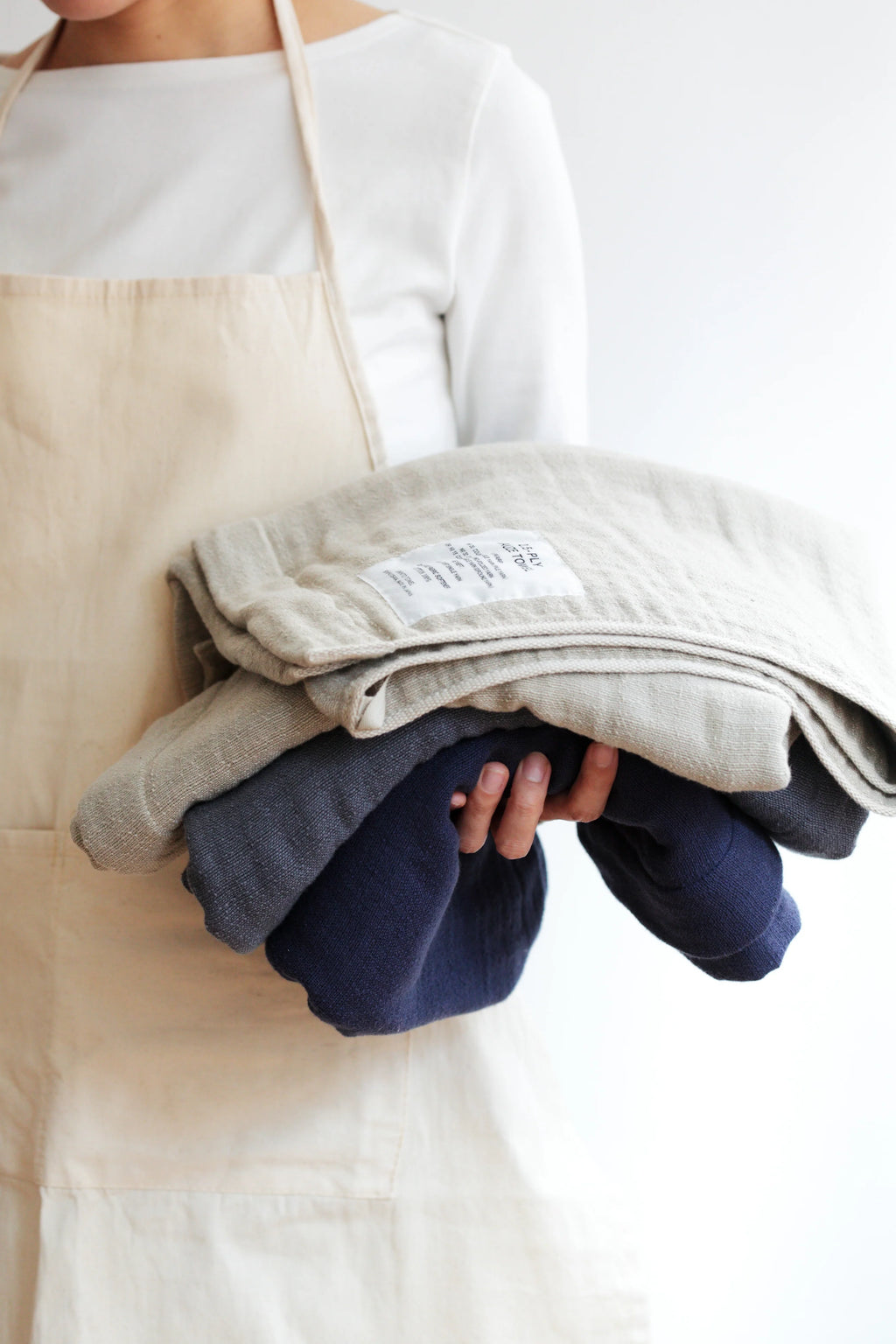 Person holding folded Shinto Towels  with a neutral background