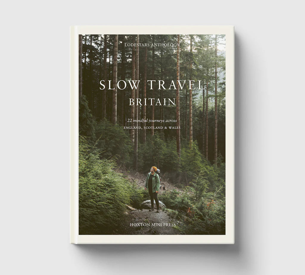 Book cover of 'Slow Travel Britain' with a person in a forest