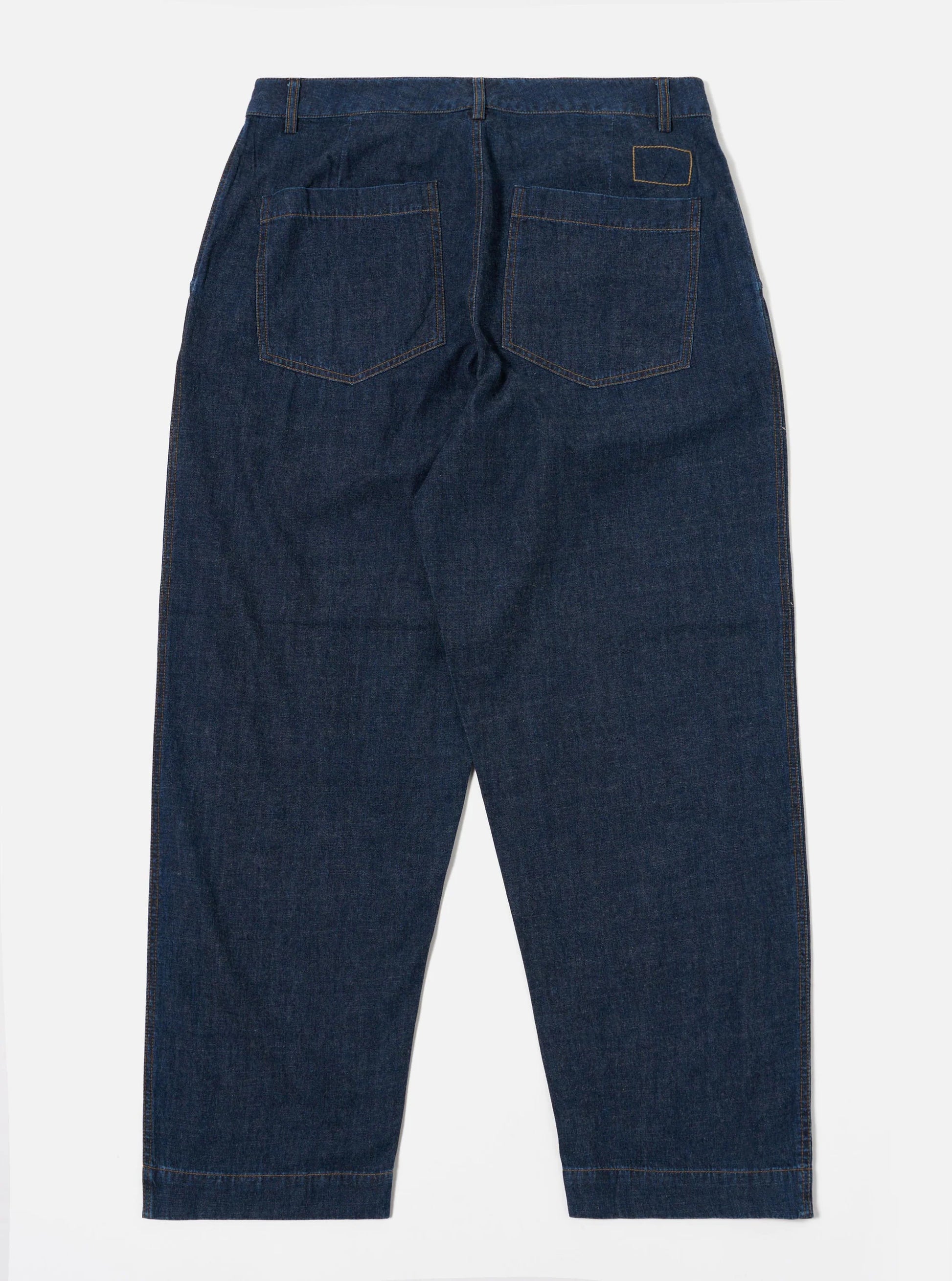 Universal Works Indigo Duke trousers against a white background 