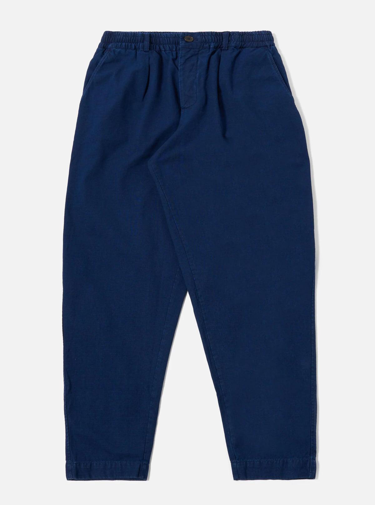 Universal Works Indigo Kimstop Pleated Track Pant against a white 