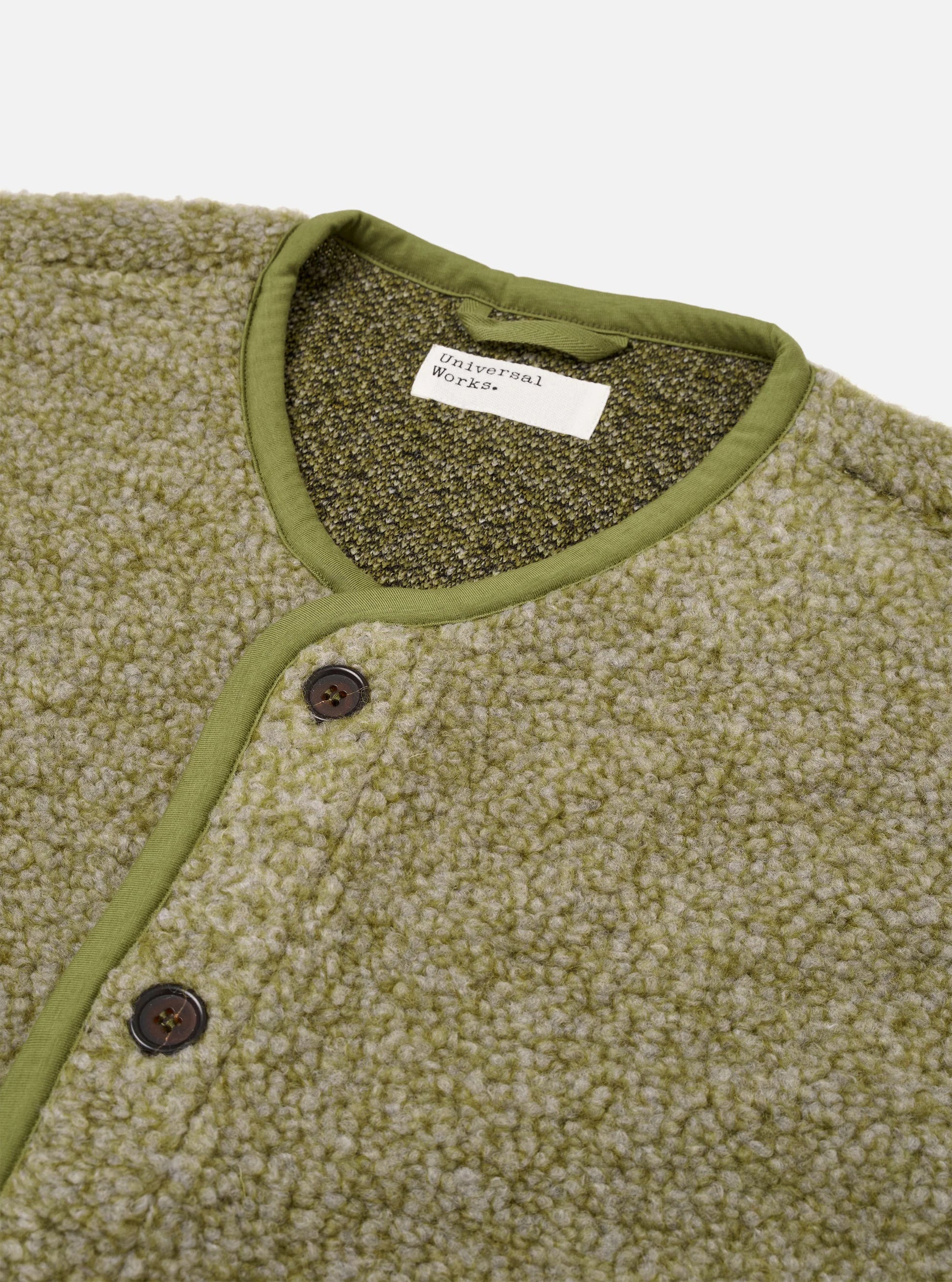 Close up the neckline and buttons  of the Universal Works Lancaster Olive coloured Gilet 
