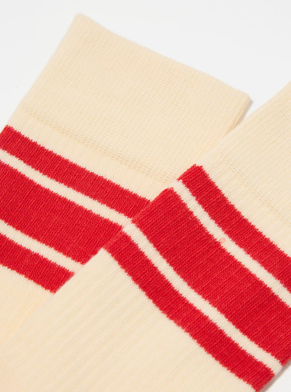 Topologie x Universal Works ecru socks with red stripes on a light grey background