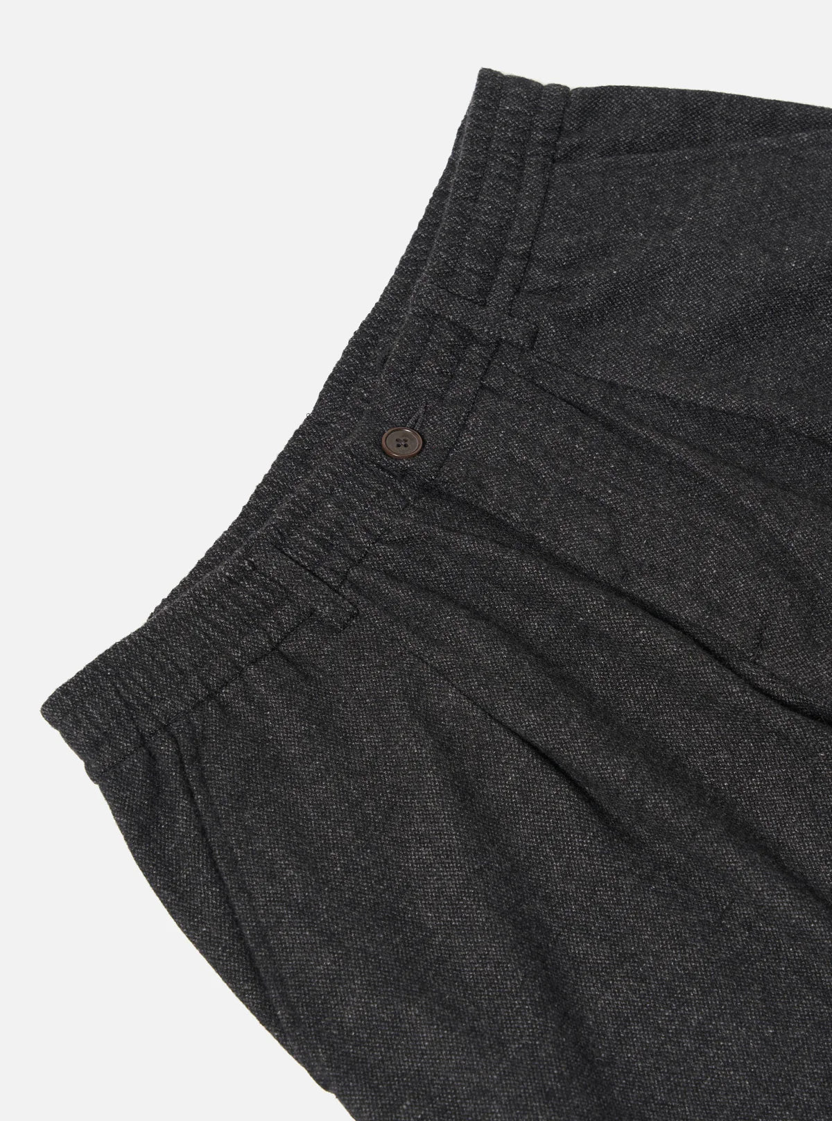 Universal Works dark grey trousers with a button on a light grey background