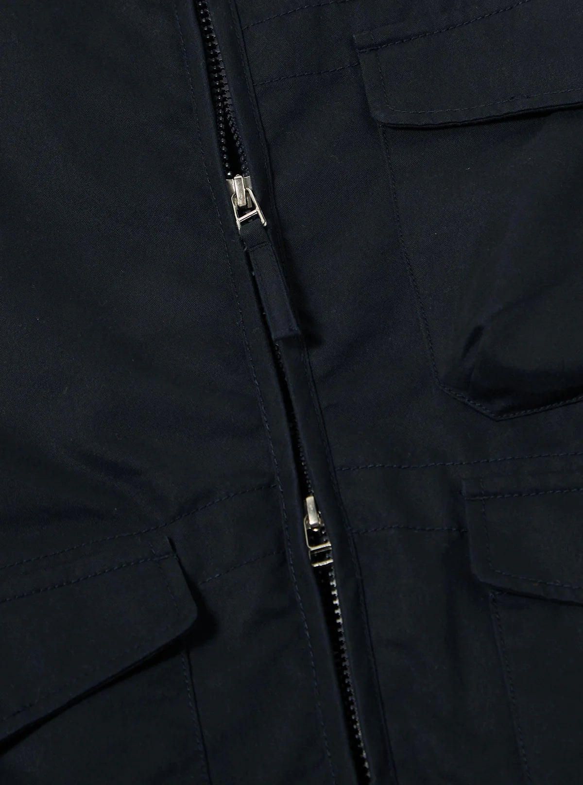 Close-up of a Universal Works navy jacket with a zipper