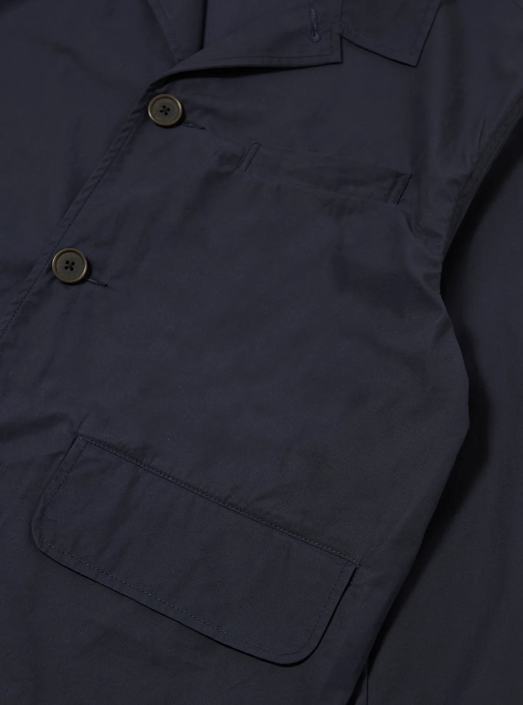 Navy jacket with button details on a dark background