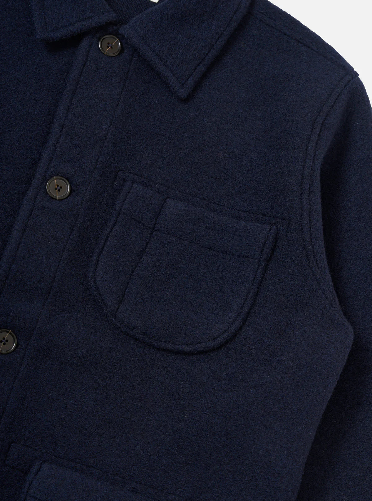 Universal Works navy blue coat with button details on a white background