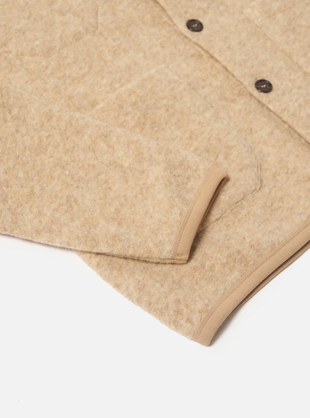 Close-up of a Universal Works beige wool fleece cardigan with buttons on a white background