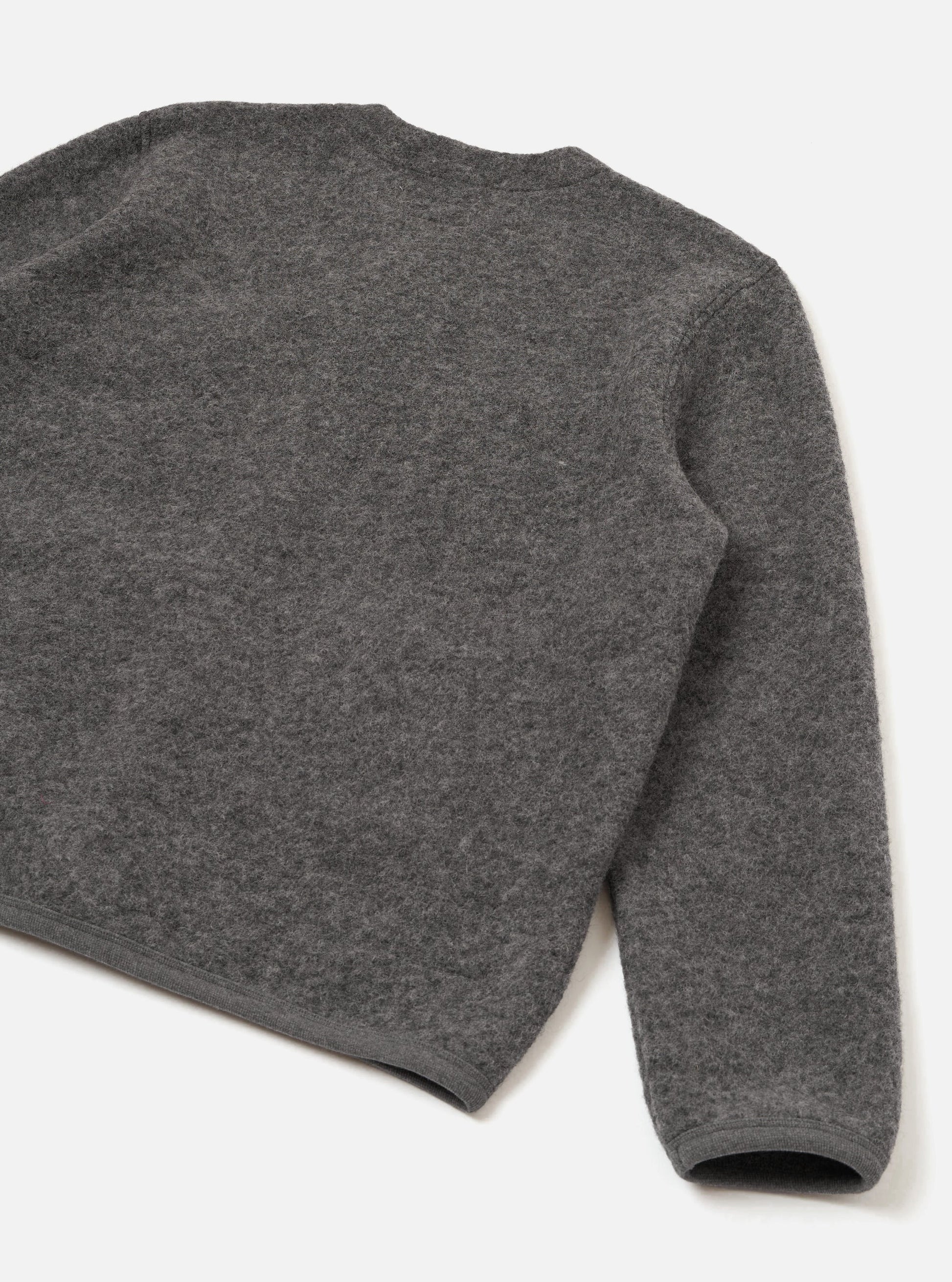 A close-up of a dark grey marl fleece cardigan, showing the texture and part of the sleeve, on a clean white background.