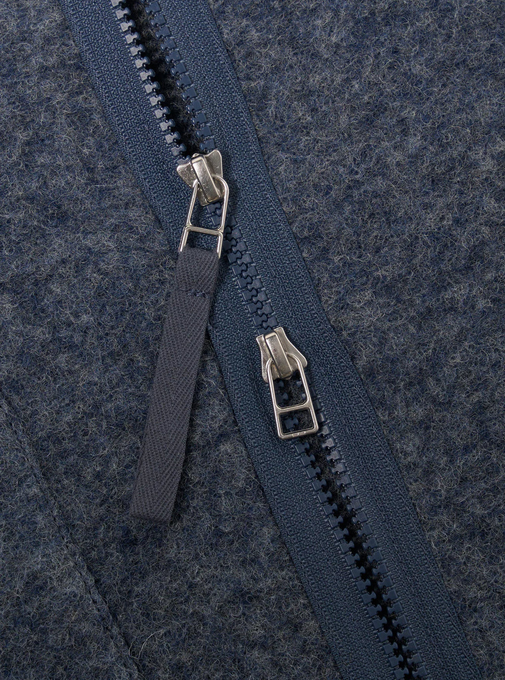 Close-up of a two way zipon a textured blue fabric background