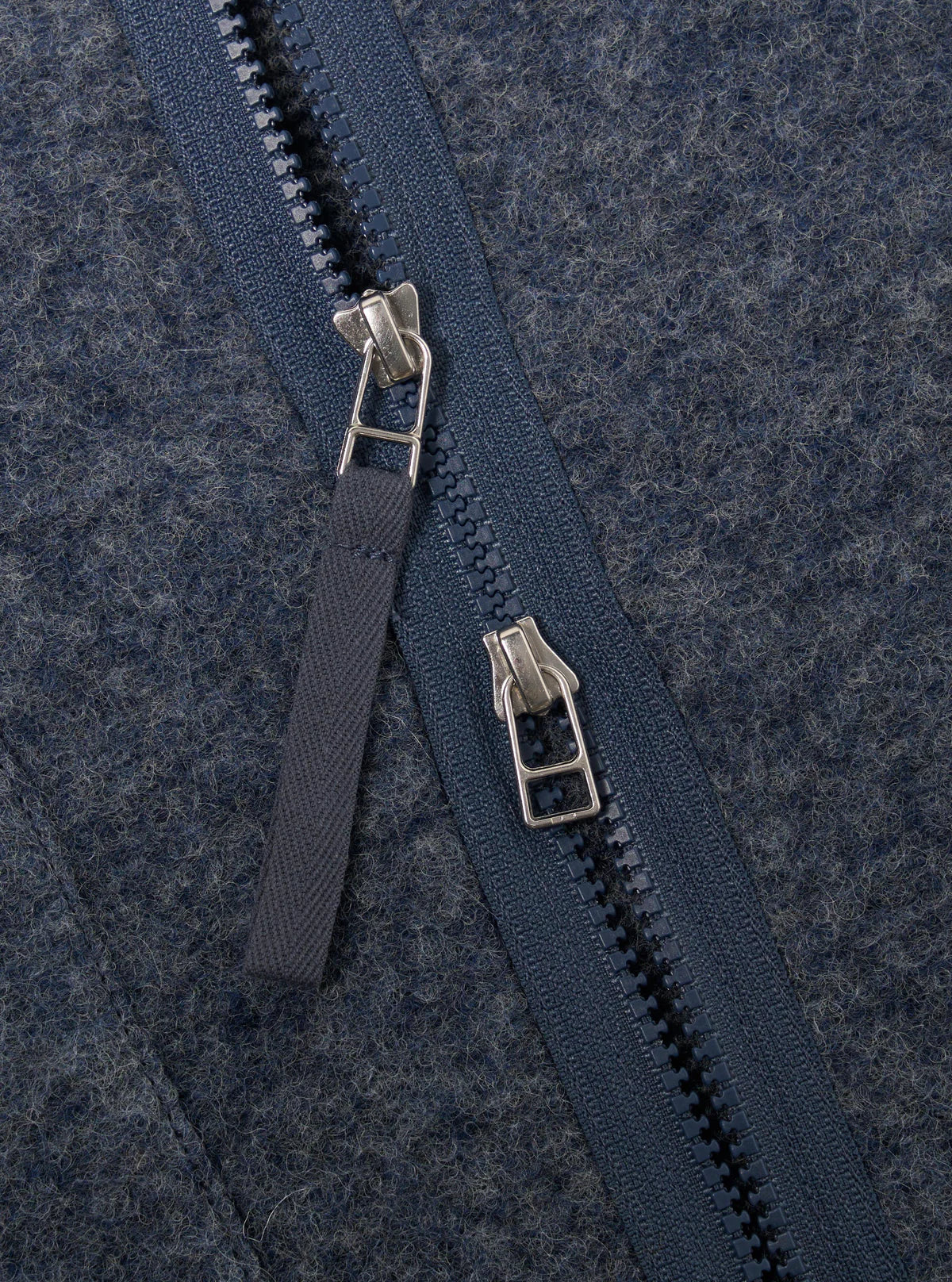 Close-up of a two way zipon a textured blue fabric background