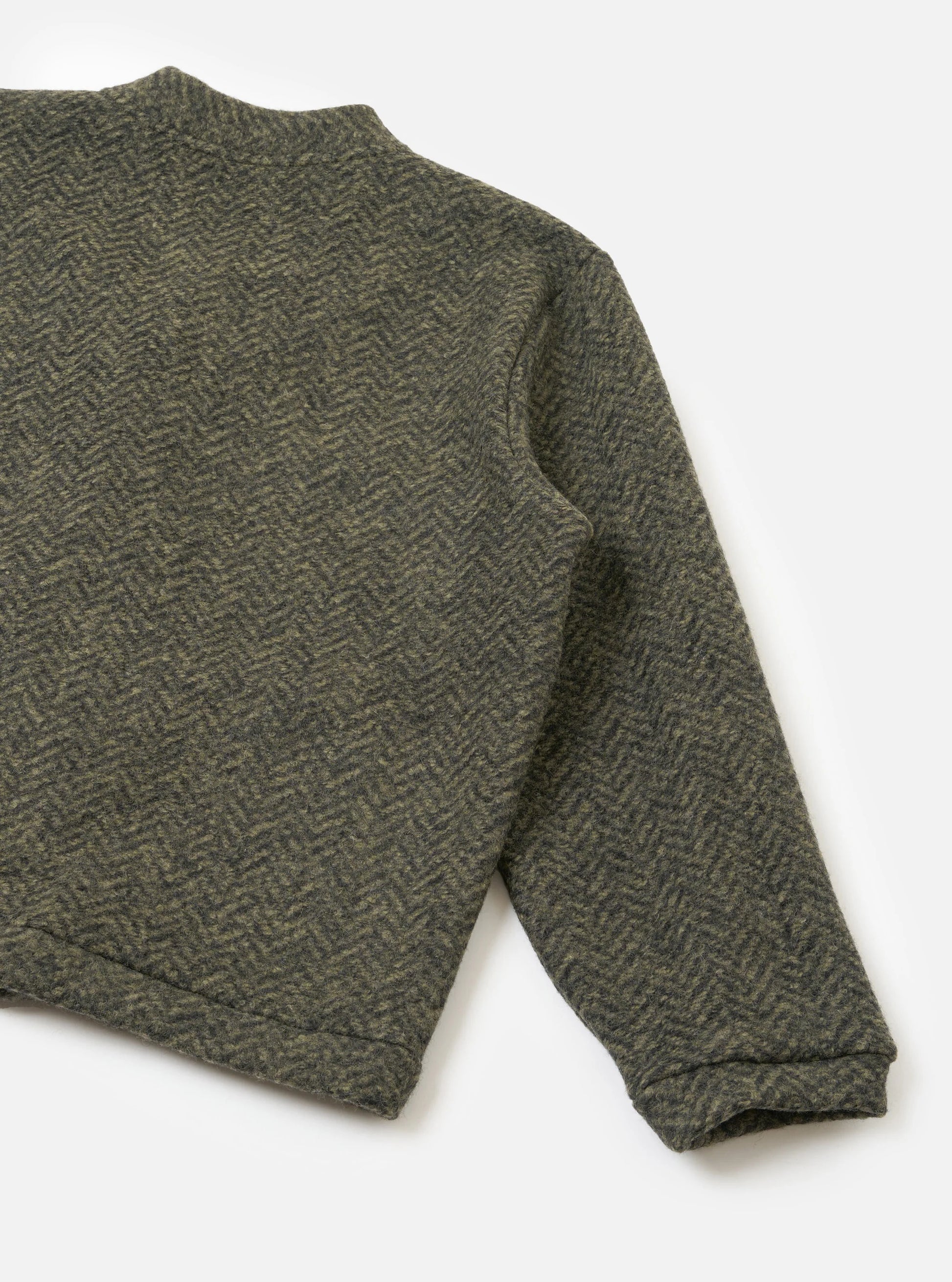 A close-up of a long-sleeve Universa; Works fleece cardigan with a textured herringbone pattern in olive green and dark brown, laid flat on a light grey background.