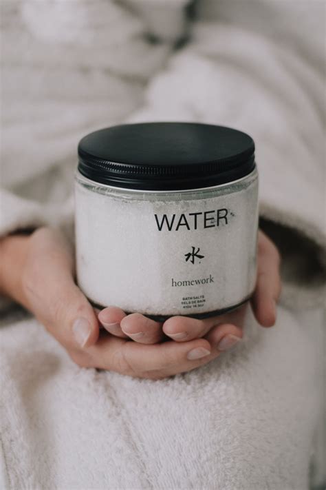 Person holding a jar labeled 'WATER' by homework.