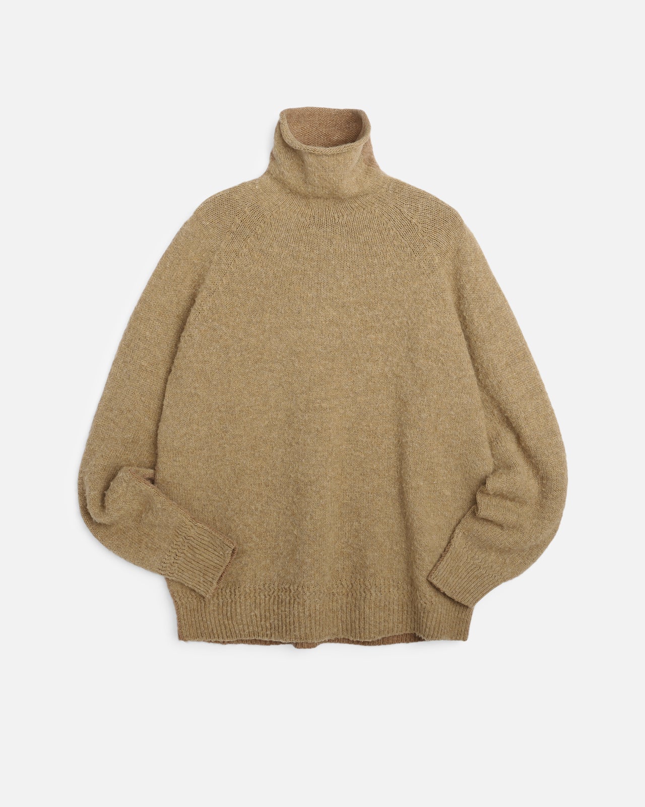 A light brown knit turtleneck You Must Create sweater with a relaxed, oversized fit, displayed against a clean, light gray background.