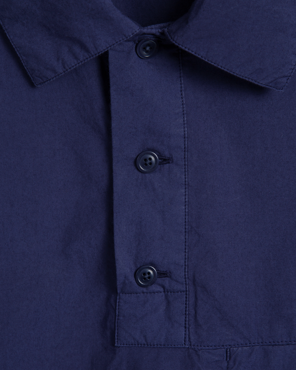 Close-up of a blue shirt with navy buttons 
